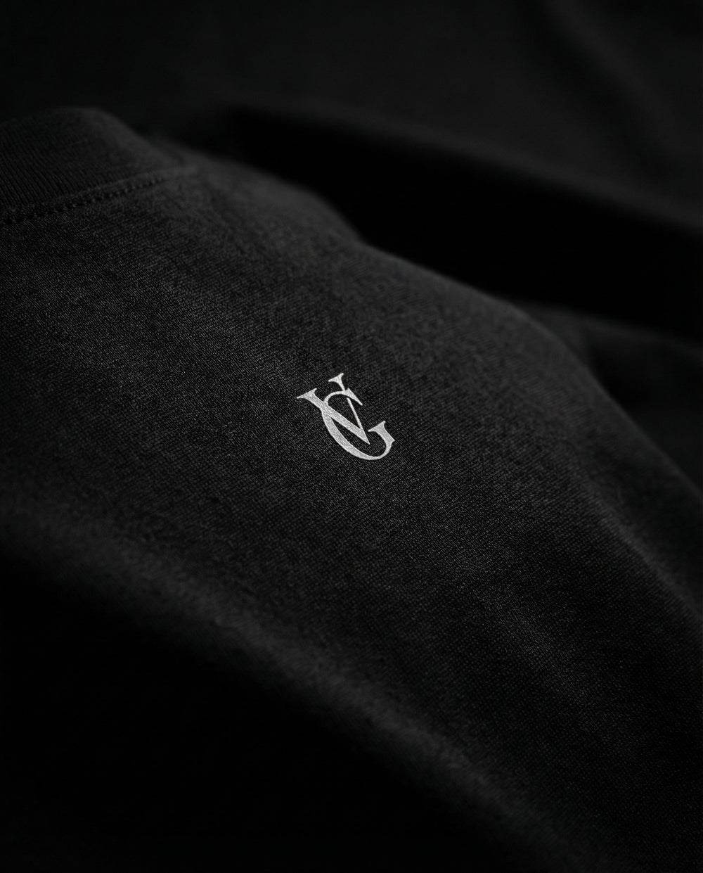 Detailaufnahme des Golden Vein Logos auf schwarzem Stoff