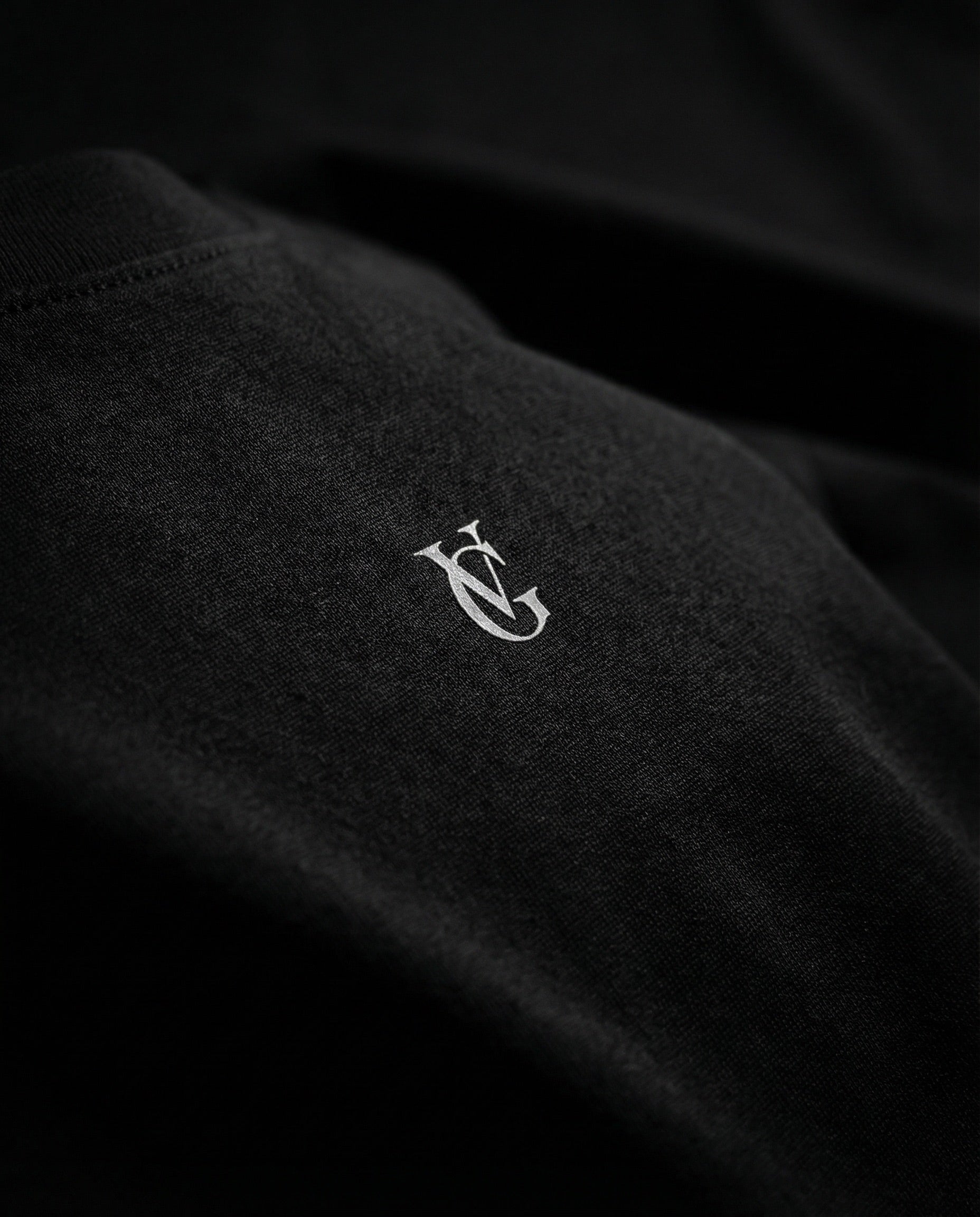 Detailaufnahme des Golden Vein Logos auf schwarzem Stoff