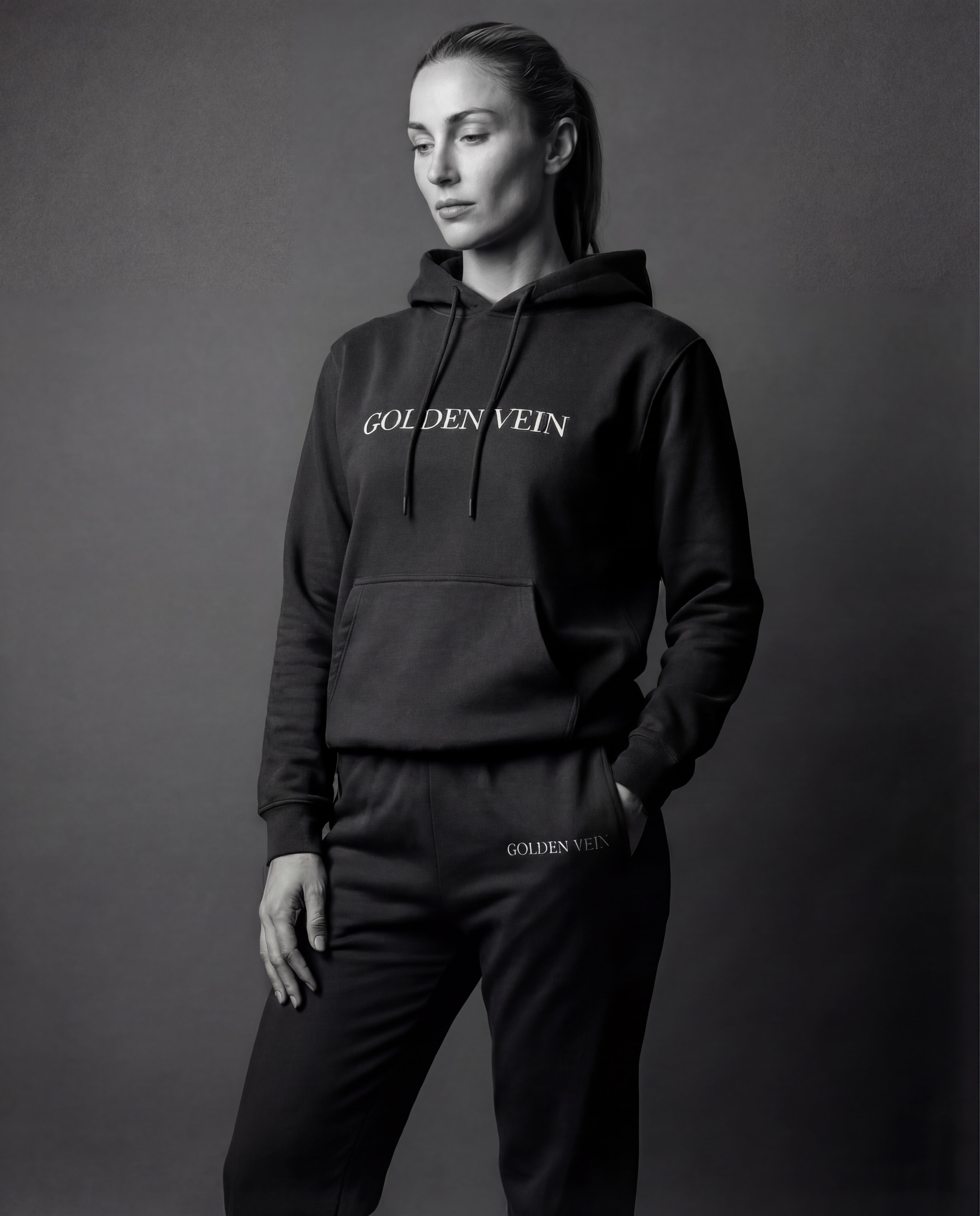 Frau trägt schwarzen Golden Vein Hoodie und Jogginghose im Studio
