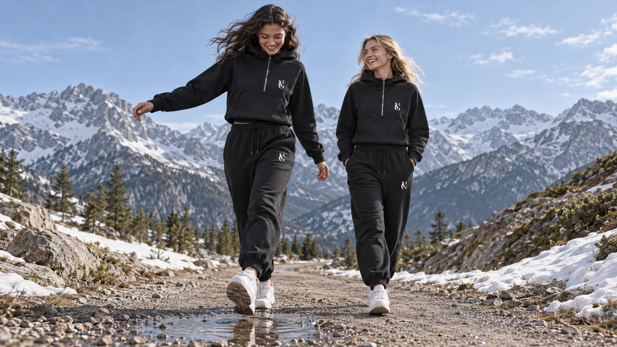 Zwei Frauen in Golden Vein Half-Zip Hoodies und Joggern auf einem Bergweg.